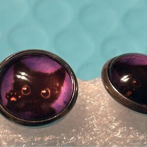 Round purple glass stud earrings featuring a black kitten